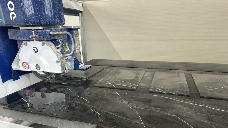 Fresa a ponte durante il taglio di una lastra di ceramica nera